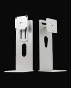 Two white metal monitor arms shown from the front and side against a plain white background.