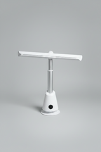 White and silver bladeless tower fan with a wide horizontal air-outlet arm, in a minimal room with a light wood desk