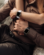 A couple seated together, one wearing the case kit on a white strap and the other on a black strap