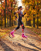 Woman on an autumn park path in hot pink and white bounce jump shoes wearing knee and wrist pads