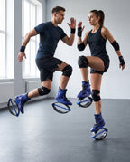 Man and woman training in blue bounce jump shoes wearing knee and wrist pads in a gym studio