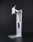 Aluminium monitor stand with VESA 100 plate and hinge arm, three-quarter view on graphite