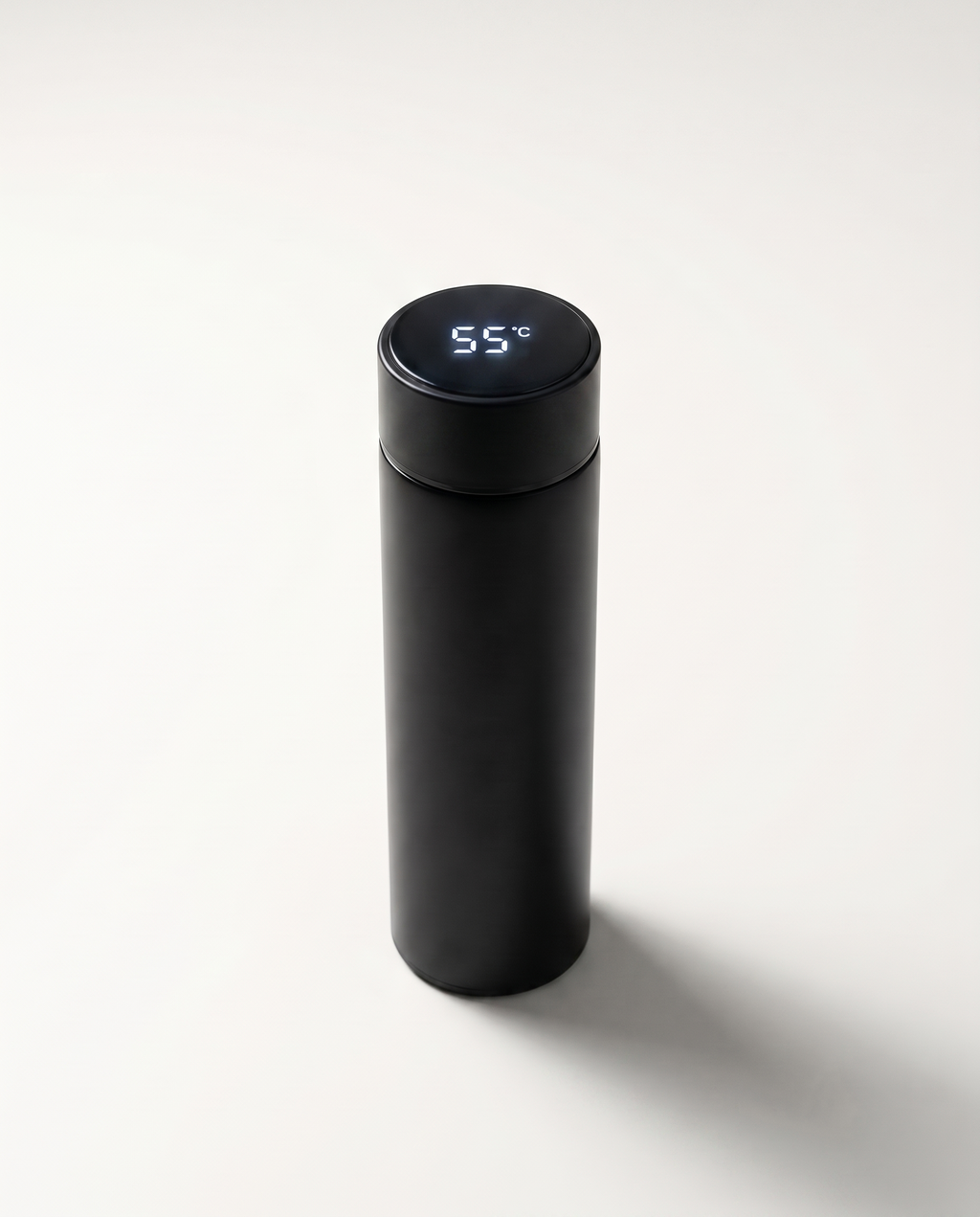 LED thermos cup in black, lid display lit and reading 55°C, on a soft white studio background