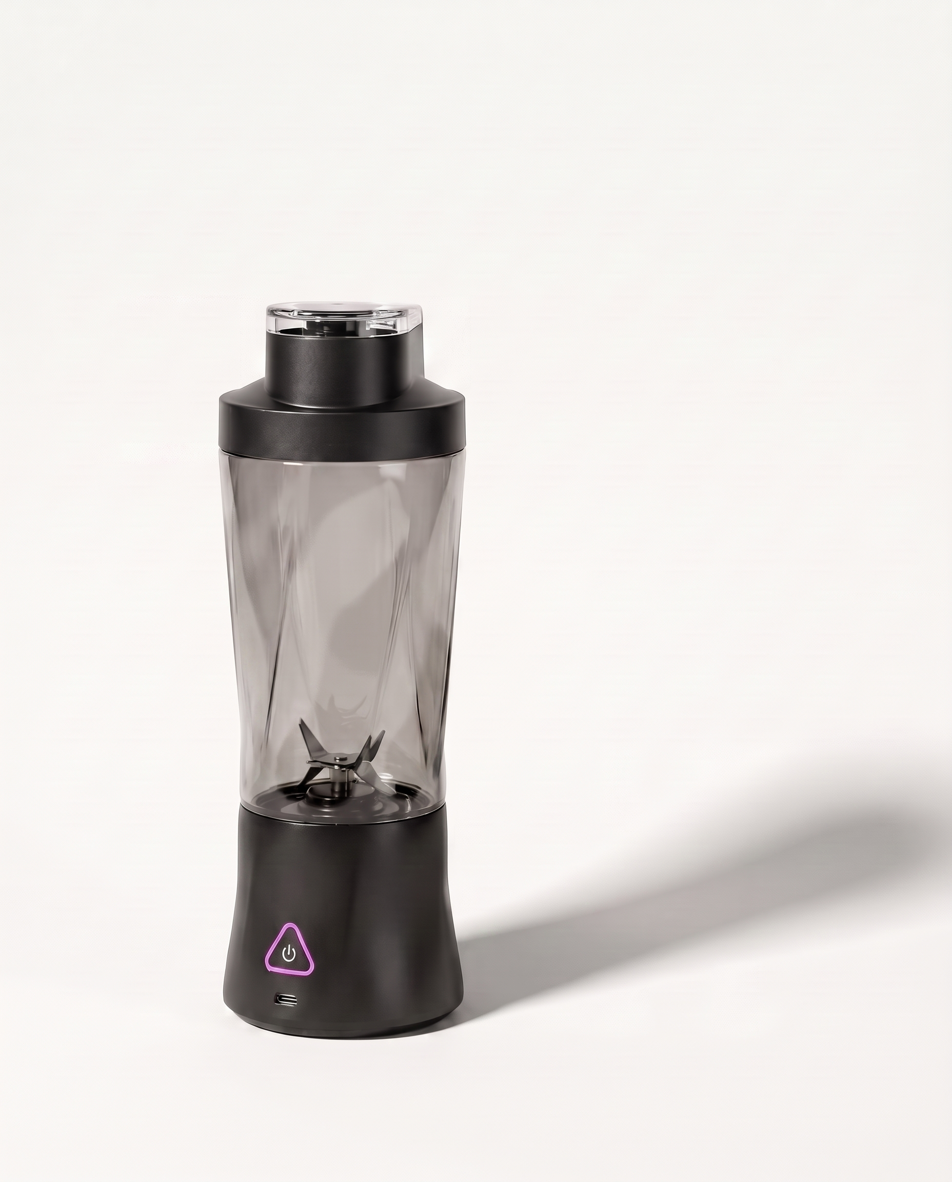 Portable blender in black with a clear tinted 700 ml bottle, six-blade assembly visible through the wall, on a soft white background