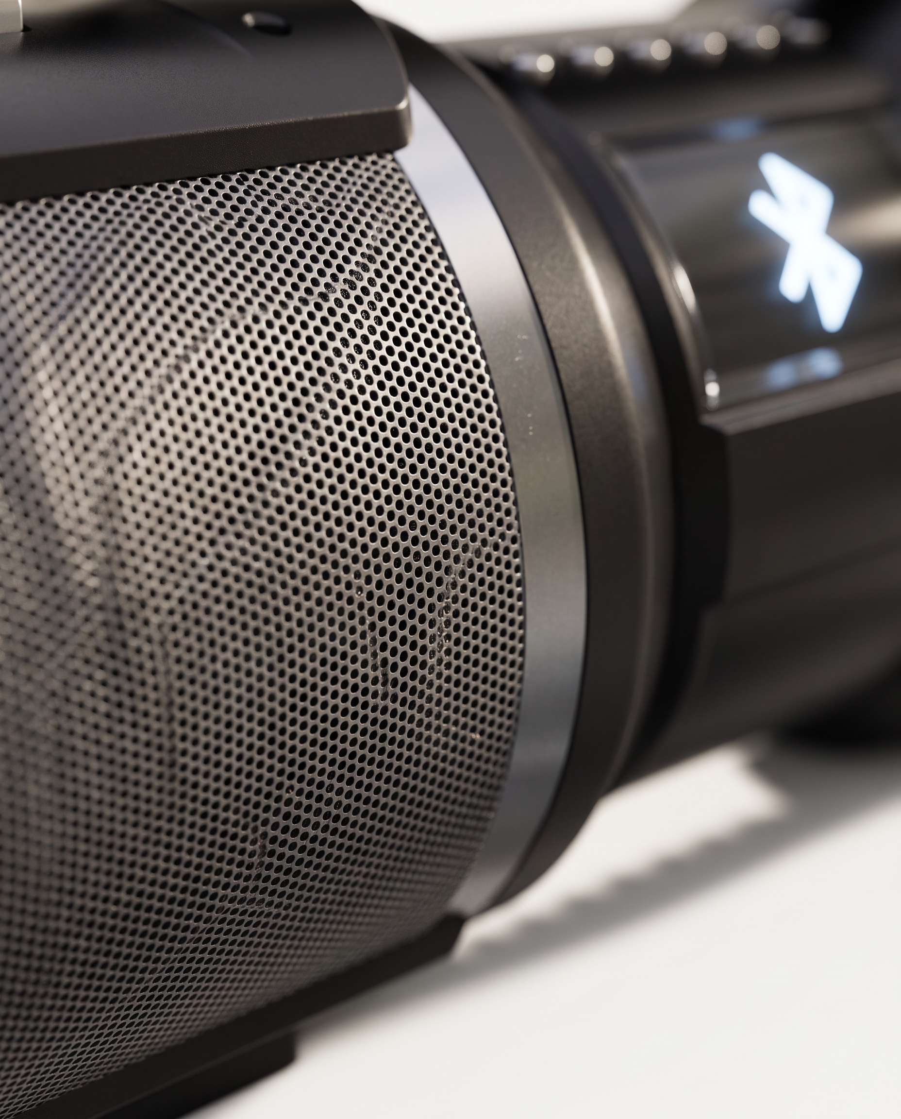 Macro detail of the speaker's perforated driver grille and the edge of the lit display panel