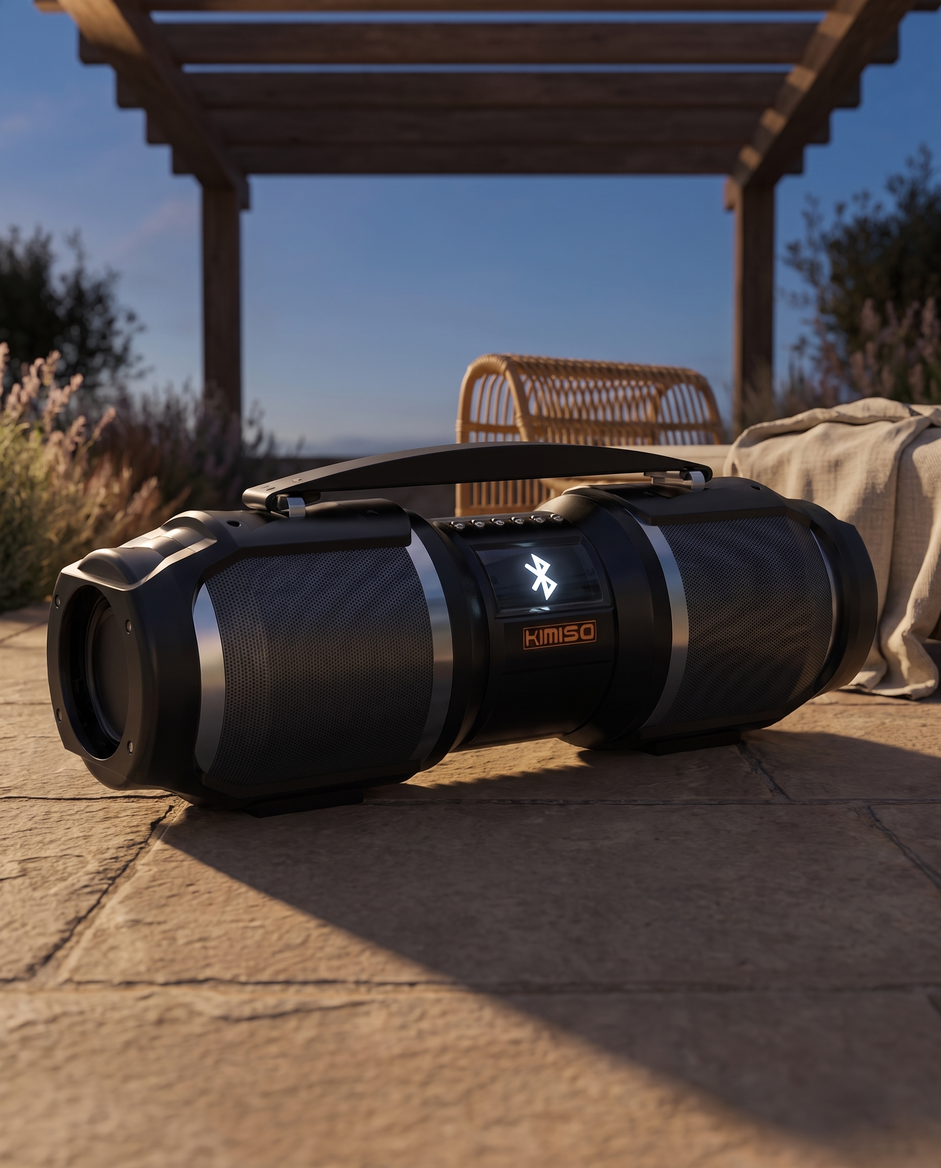 The Bluetooth speaker on stone paving under a timber pergola at dusk