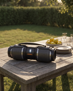 The Bluetooth speaker on a long timber table laid for a garden party in late afternoon sun