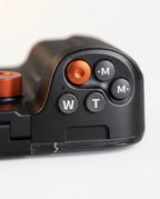 Close view of the five-key control cluster, with the orange capture button alongside the mode and zoom keys.