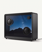 Floating lyrics speaker in matte black with a 21.5 inch transparent screen showing a night sky